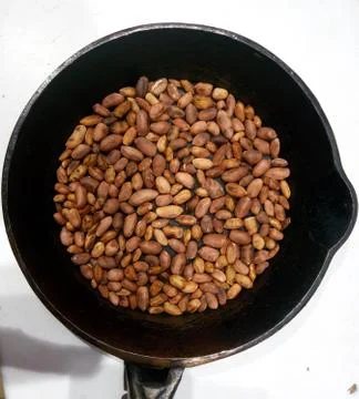 Roasted peanuts in a pan on a white background Stock Photos
