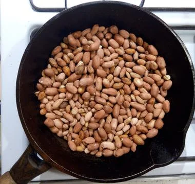 Roasted peanuts in a pan on a white background Stock Photos
