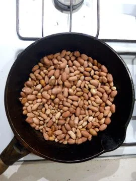 Roasted peanuts in a pan on a white background Stock Photos