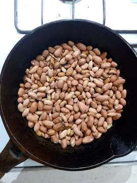 Roasted peanuts in a pan on a white background Stock Photos