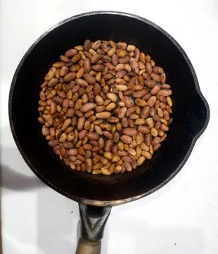 Roasted peanuts in a pan on a white background Stock Photos