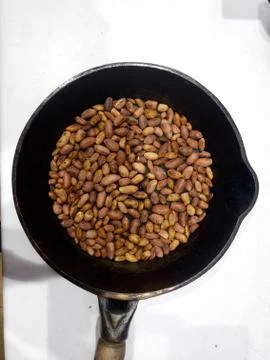 Roasted peanuts in a pan on a white background Stock Photos