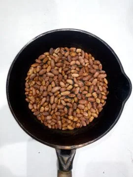Roasted peanuts in a pan on a white background Stock Photos
