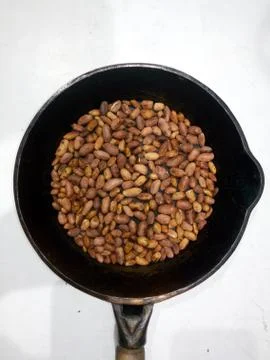 Roasted peanuts in a pan on a white background Foto stock