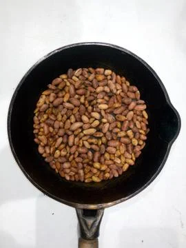 Roasted peanuts in a pan on a white background Stock Photos