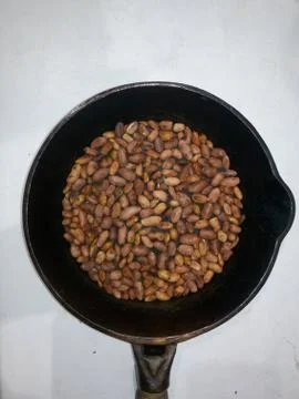 Roasted peanuts in a pan on a white background Stock Photos