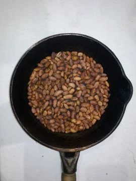 Roasted peanuts in a pan on a white background Stock Photos