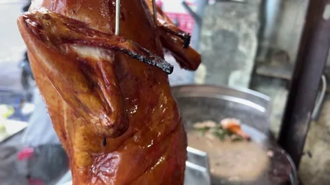 Roasted Peking ducks with glistening skins are on display, hanging in a typical Video stock 308337659