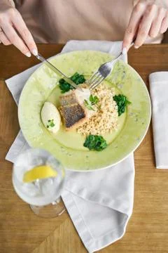 Roasted Pike perch with spelt and Polish sauce. Lunch in a restaurant, a woman Stock Photos