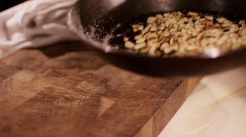 Roasted pine nuts, tossing in a frying pan Stock Footage