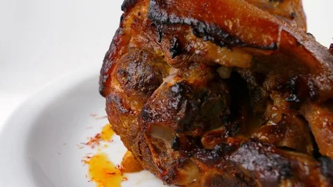 Roasted pork knuckle with potatoes and vegetables, close-up view Stock Footage 80143495