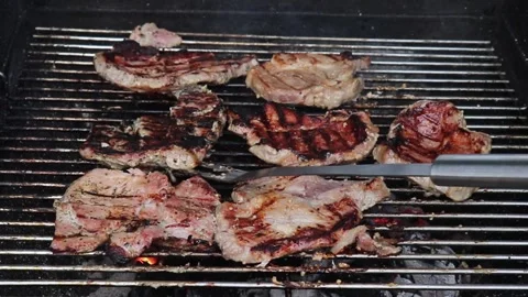 Roasted Pork Meat On The Grill. The Hand Shifts Pieces Of Burnt Flesh. Barbecue. Stock Footage 241006142