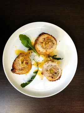 Roasted pork roll stuffed with vegetables on wooden board with dill. Foto stock