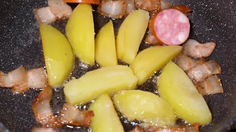 Roasted potatoes and meat cooked in frying pan with vegetable oil Stockbeeldmateriaal 251541065