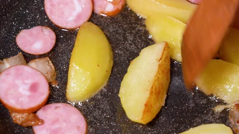 Roasted potatoes and meat cooked in frying pan with vegetable oil Stockbeeldmateriaal 251541578