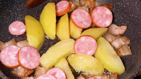 Roasted potatoes and meat cooked in frying pan with vegetable oil Stockbeeldmateriaal 251541765