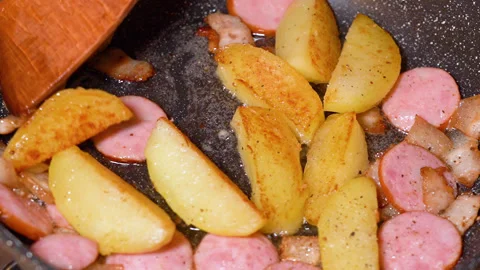 Roasted potatoes and meat cooked in frying pan with vegetable oil Stockbeeldmateriaal 251542511
