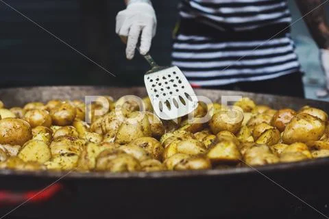 Roasted potatoes cooked in metal cauldron pot Stock Photos