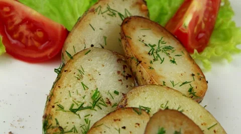 Roasted potatoes with leaf of salad, dill and tomato, closeup Stock Footage 63543866