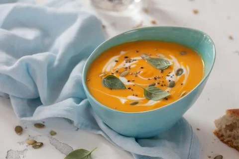 Roasted pumpkin and carrot soup with cream and pumpkin seeds Stock Photos
