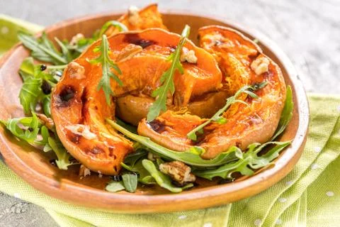 Roasted pumpkin with pecan nuts and arugula. Stock-Fotos