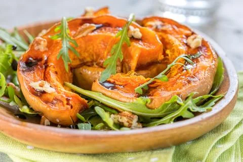 Roasted pumpkin with pecan nuts and arugula. Stock Photos