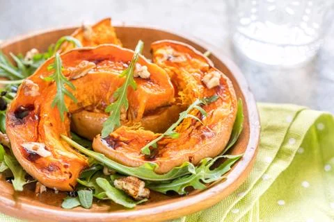 Roasted pumpkin with pecan nuts and arugula. Stock-Fotos