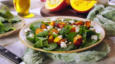 Roasted pumpkin salad with spinach, tomatoes and nuts Stock Footage 103739438