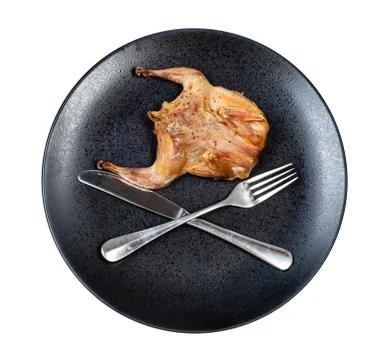Roasted quail with crossed fork and knife on plate Stock Photos