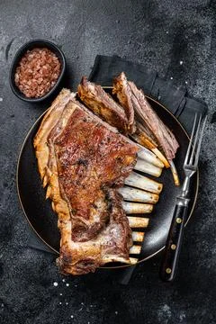 Roasted Rack of lamb ribs, mutton spareribs, sliced meat on plate. Black Stock Photos