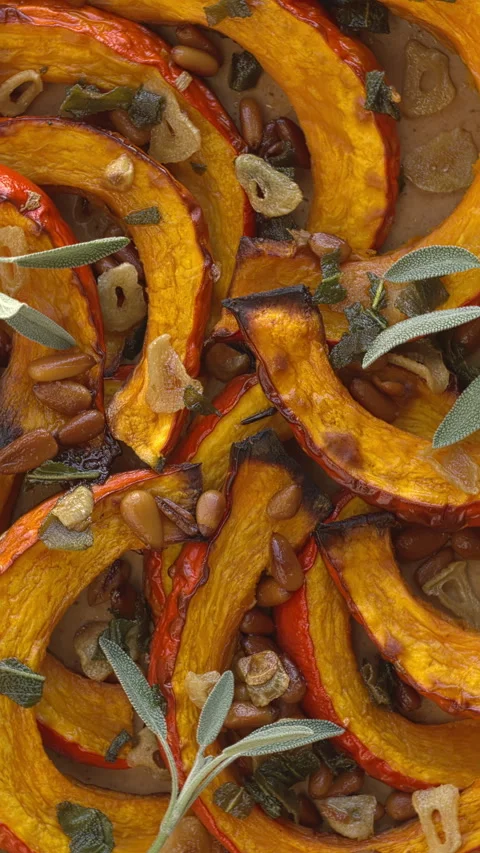 Roasted Red Kuri Squash with sage and pine nuts background. Vertical video. Stock Footage 308075525