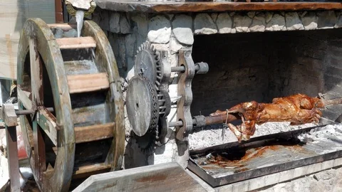 Roasted rotating on a spit moved by the water Stock Footage 91037866