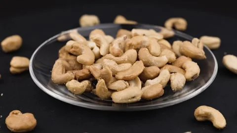 Roasted salted cashew nuts on the plate. Stock Footage 308927550