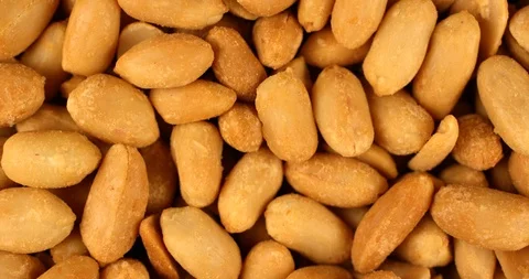 Roasted salted peanuts rotating in slow motion. Extreme close up top view, shot Stock Footage 107388650