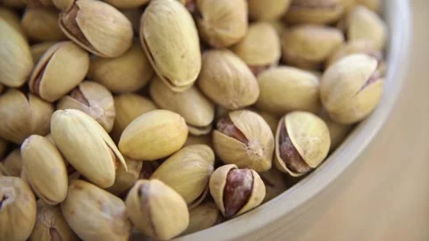 Roasted salted pistachios in shells rotating in a bowl Stock Footage 333830848