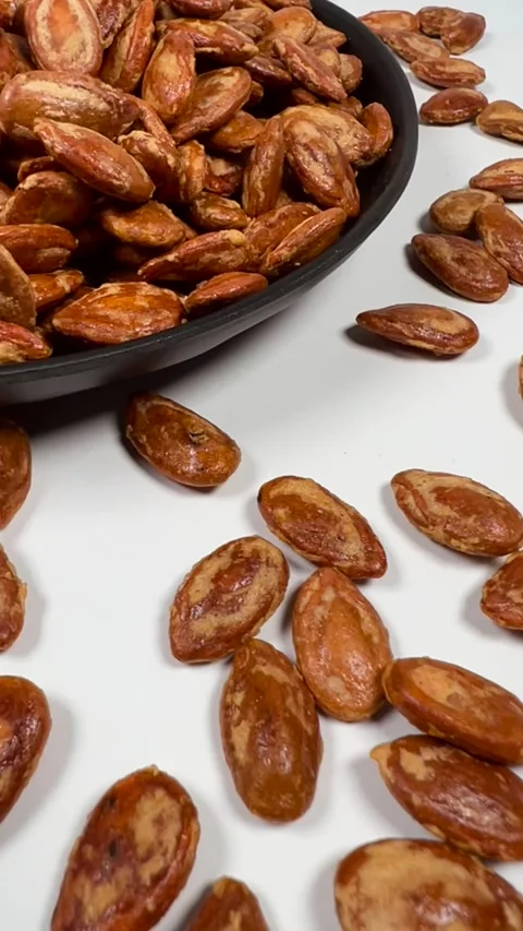Roasted salted watermelon seeds scattered on white background Stock Footage 336847747