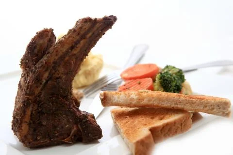 Roasted sheep meat with bones on dish Stock Photos