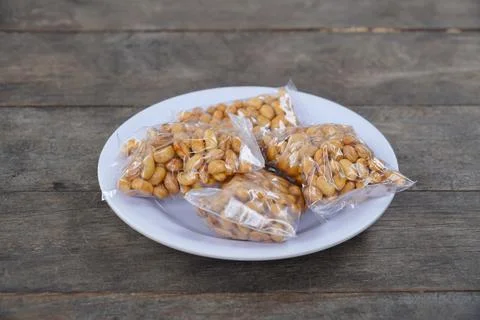 Roasted soybeans In Transparent Small Plastic Packaging on a white plate. O.. Stock Photos