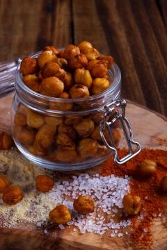 Roasted spicy chickpeas on rustic background Stock Photos