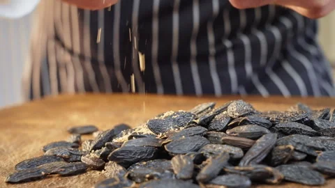 Roasted sunflower seeds being spread, warm lighting highlights rustic snack Video stock 324575701