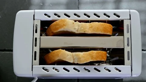 Roasted toast bread popping up from toaster machine, top view Video stock 73687306