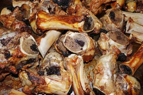 Roasted veal marrow bone or beef bone from the oven for stock or sauce prepar Stock Photos