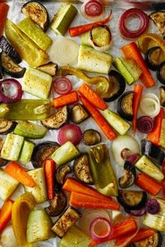 Roasted vegetables mix on baking tray, food above. Vegan food Stock Photos