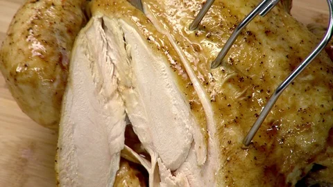 Roasted whole chicken with thyme. Closeup slice with large carving knife Stock Footage 102137573