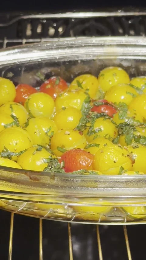 Roasted yellow and red cherry tomatoes seasoned with herbs and oil, baking .. Video stock 344398474