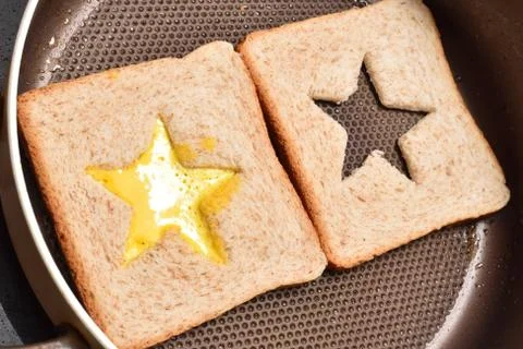 Roasting bread toasts with a star-shaped middle and omelette filled with egg  Stock Photos