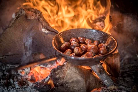Roasting chestnuts on fire in a pan Stock Photos