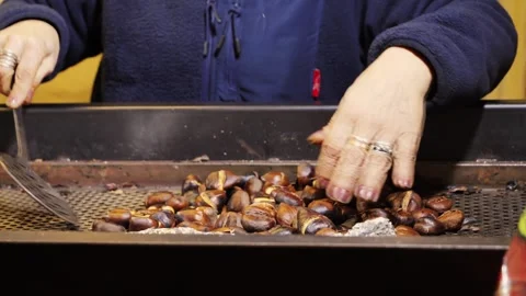 Roasting chestnuts on open fire in the street Spain, popular autumn street food Stock Footage 301608270