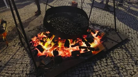 Roasting chestnuts on an open fire in the streets of Portugal. Stock Footage 346629585
