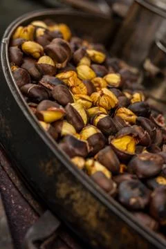 Roasting chestnuts over an open fire. Typical warm autumn snack Stock Photos